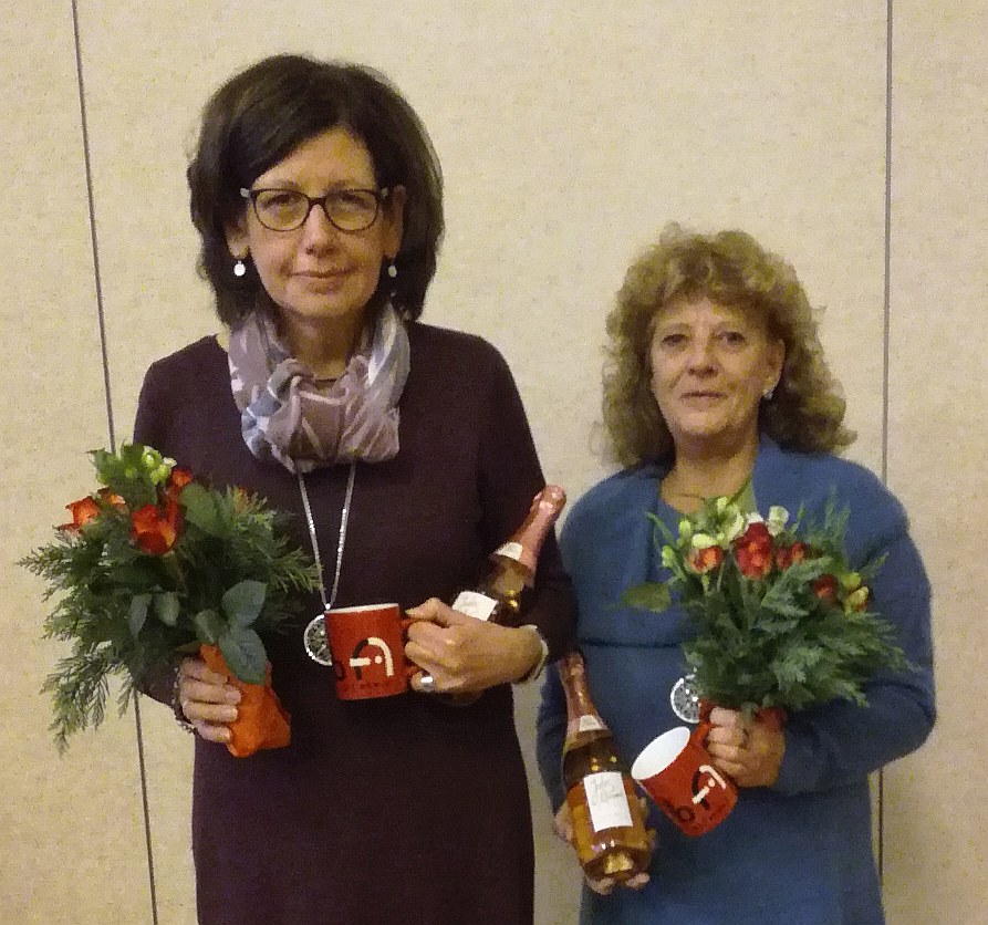 Birgit Seikrit und Elisabeth Krych mit Dankespräsenten: Blumen, Tasse, Sekt